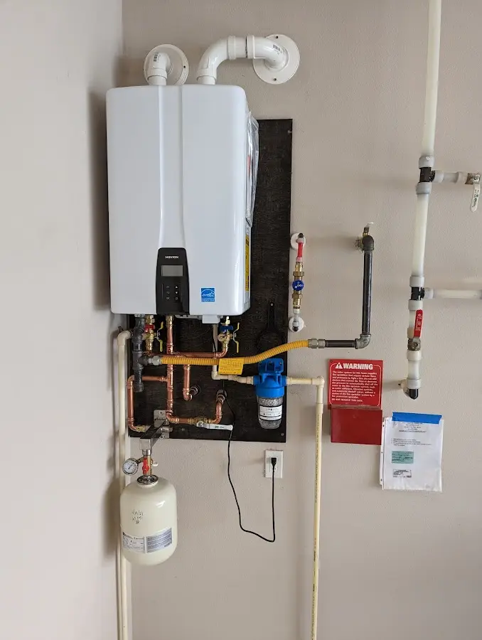 Professional plumber installing copper piping in a Throop home